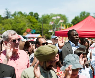 New citizens to Canada take the oath of citizenship at a citizenship ceremony