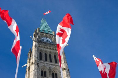 Canadian flags fluttering in front of parliament building 