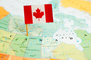Canadian flag pinned over map of Canada 