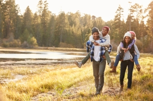 study-in-canada A young family walking by a lake in Canada