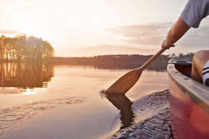 A man paddling a kayak on a lake in Manitoba, Canada