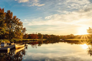 Sunset over a lake in Nova Scotia, Canada with a long kayak moored to a short jetty in the foreground