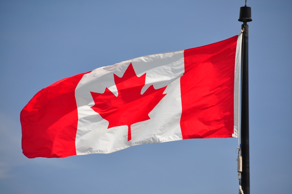 Canada flag 
 with mountain view on the background.