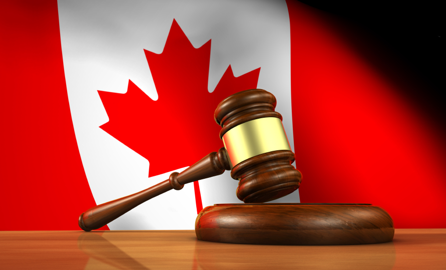 A gavel resting in front of a Canadian flag