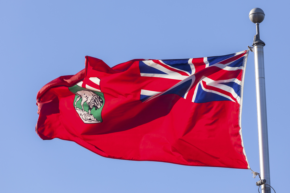 Manitoba flag against blue sky.