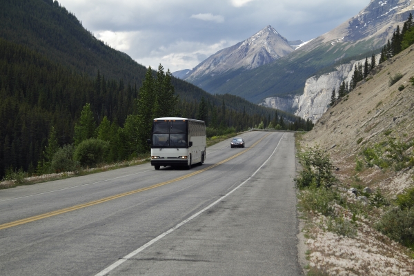 Tour bus driving through the Rocky Mountains near Jasper, Alberta, Canada