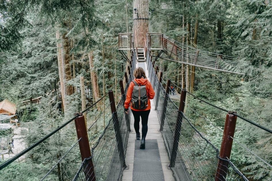 A girl with a backpack crossing Capilano Bridge in Vancouver, British Columbia.